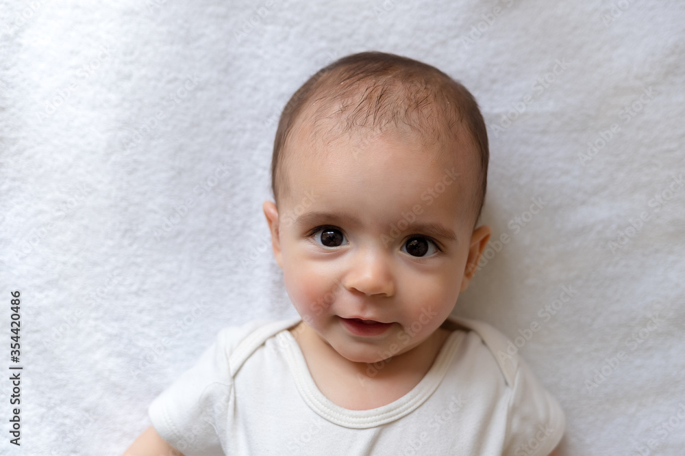 Newborn baby. A little boy in white clothes. Beautiful portrait of a toddler. Big-eyed baby. Newborn baby. A little boy in white clothes. Beautiful portrait of a toddler. Big-eyed baby.