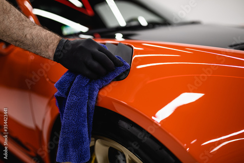 A man cleaning car with cloth, car detailing (or valeting) concept. Selective focus. © hedgehog94