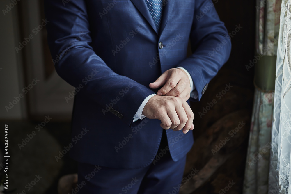 Businessman wears a jacket, male hands closeup,groom getting ready in the morning before wedding ceremony