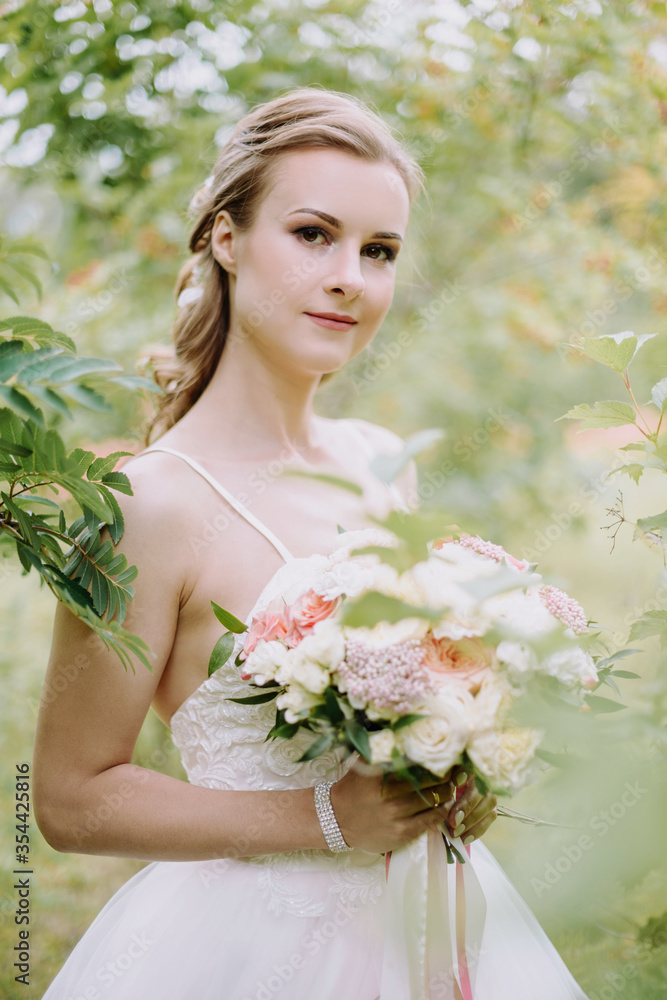 Portrait of a beautiful bride in a beautiful wedding dress with a luxurious bouquet of pink and white roses Portrait of a beautiful bride in a beautiful wedding dress with a luxurious bouquet of pink and white roses