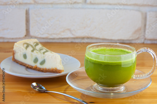appetizing green cheesecake with matcha tea on wooden background