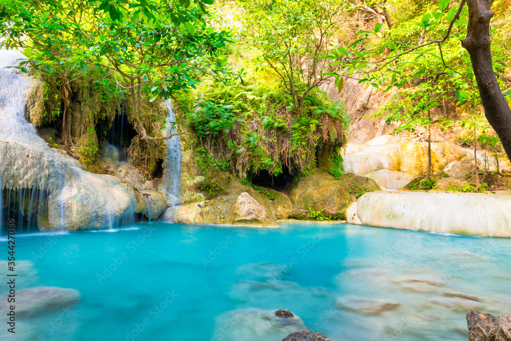 Naklejka premium Emerald blue lake with rock cascades of stream waterfall in tropical jungle forest. Landscape of Erawan National park, Kanchanaburi, Thailand