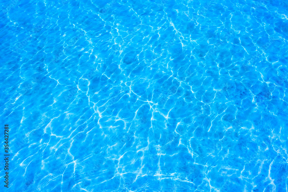 Texture of a blue water surface with light reflections