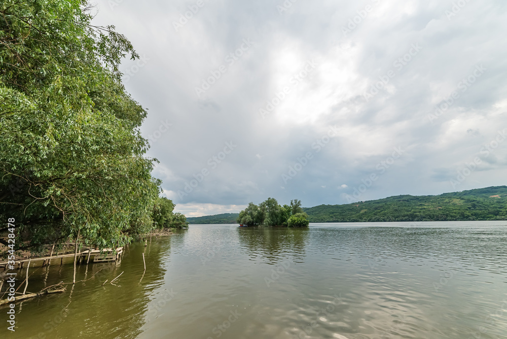 An island on the Danube. River island in the Danube, under the cloudy sky