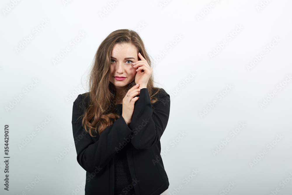 Young Attractive Woman Brunette In In A Black T-Shirt And Sweater On White Background, Cute Female Holding Hands Near Her Face, Gentle Person Young Attractive Woman Brunette In In A Black T-Shirt And Sweater On White Background, Cute Female Holding Hands Near Her Face, Gentle Person