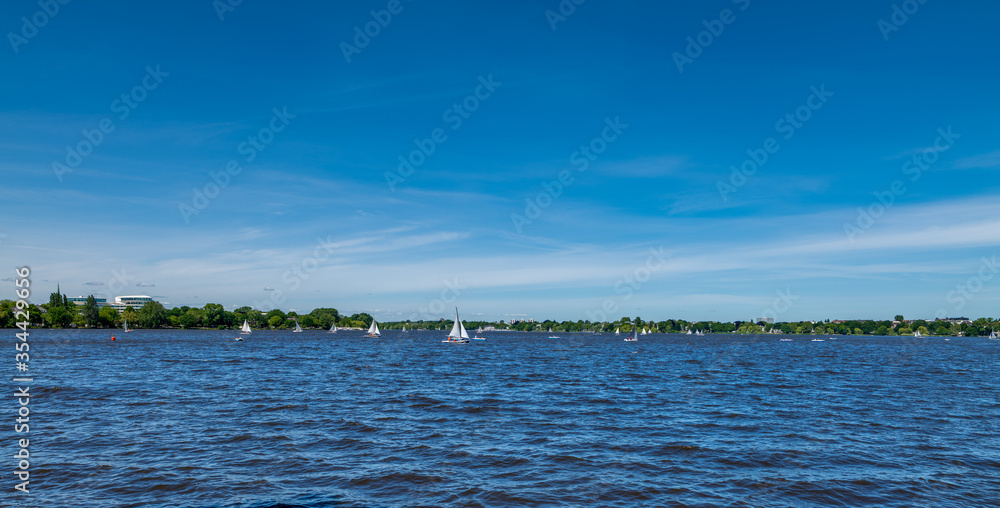 Hamburg, Germany. The Alster lake (German: Aussenalster) with sail boats on a sunny day. Hamburg, Germany. The Alster lake (German: Aussenalster) with sail boats on a sunny day.
