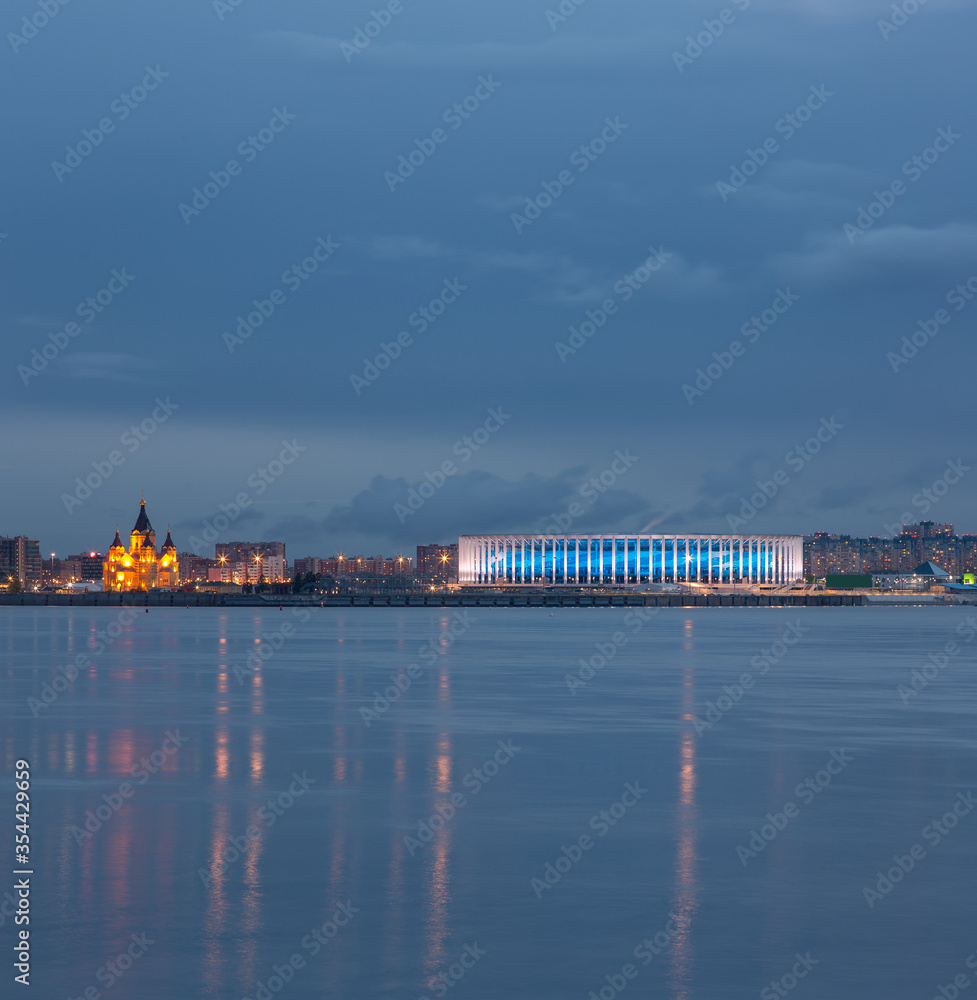 Nizhny Novgorod. The original view of the city, arrow, stadium and Alexander Nevsky Cathedral in the evening with the lights of the night city and a lead sky