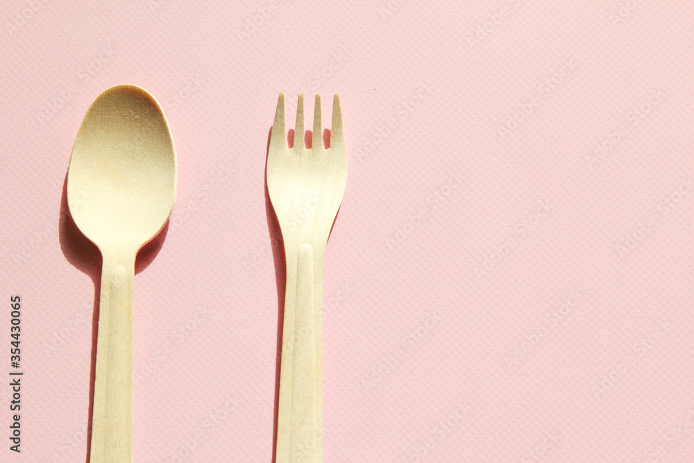Spoon and fork on the pink background. Eco-friendly tableware. Spoon and fork on the pink background. Eco-friendly tableware.