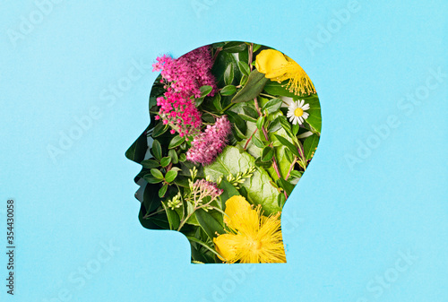 Papercut head with green leaves and flowers. Mental health, emotional wellness, contented emotions, self care, psychology, green thinking, ecology photo