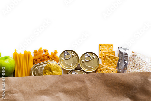 Food delivery, Donation. Food supplies crisis food stock for quarantine isolation period on white background. Pasta, canned food, apples, oil, crackers.
