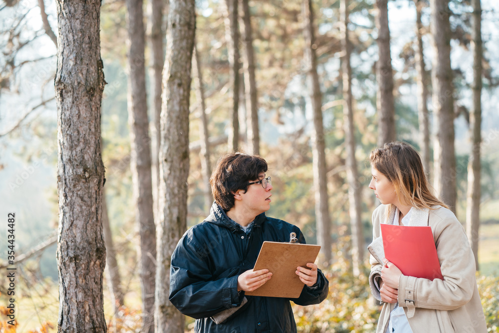 Scientists are studying plant species and inspect trees in the forest. Scientists are studying plant species and inspect trees in the forest.