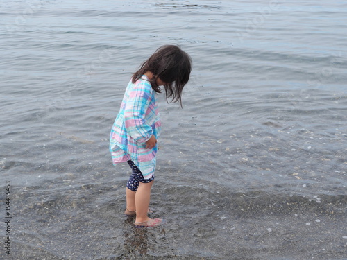 Fototapeta Naklejka Na Ścianę i Meble -  Girl child putting feet on the beach