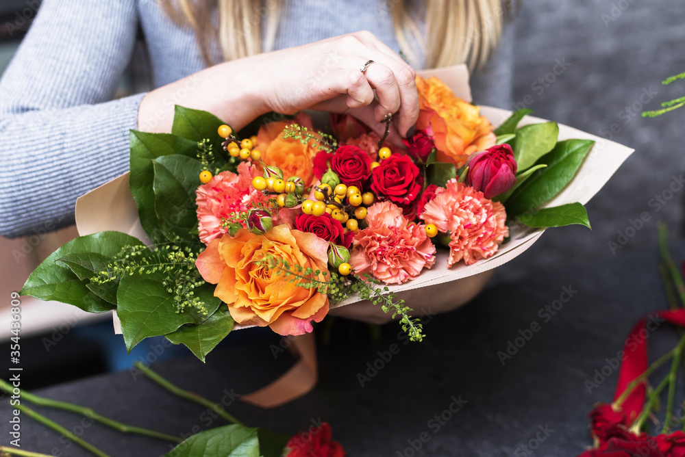 Girl collects a bouquet of various flowers. Small business