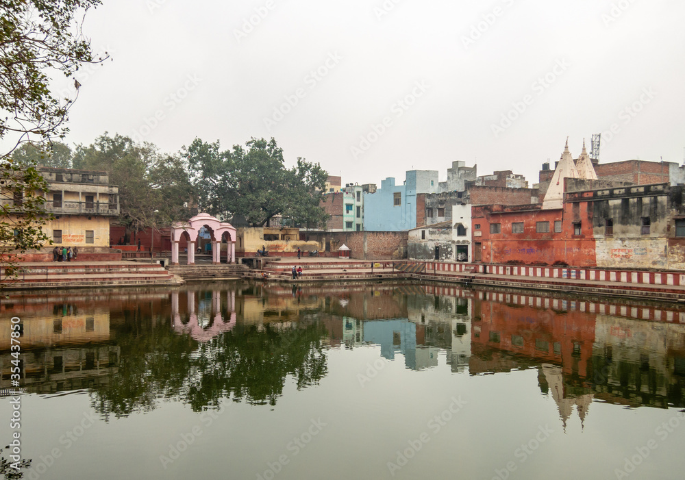 Ancient temples reflected in water of a tank in the city of Varanasi in India.