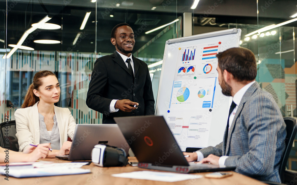 Business meeting. Business people in formalwear discussing something while sitting together at the table Business meeting. Business people in formalwear discussing something while sitting together at the table