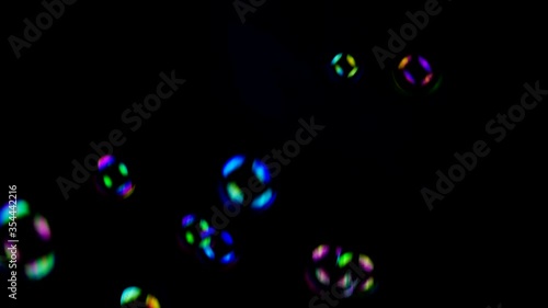 Falling soap bubbles on black background