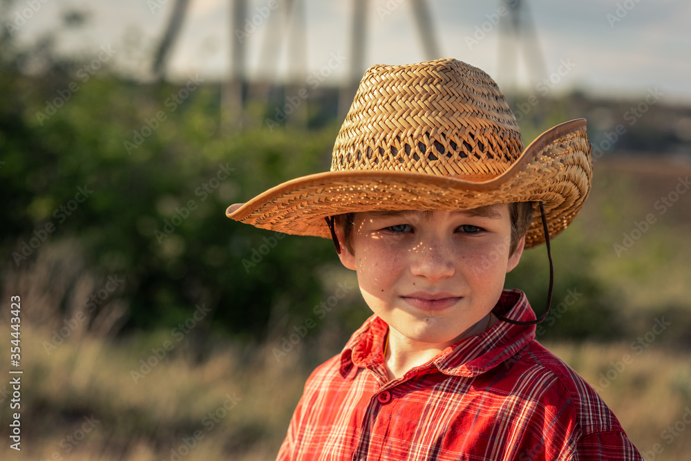 portrait of a boy, a child in a straw hat and a red shirt