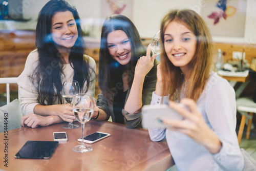 Three female friends enjoying meeting in cozy cafe