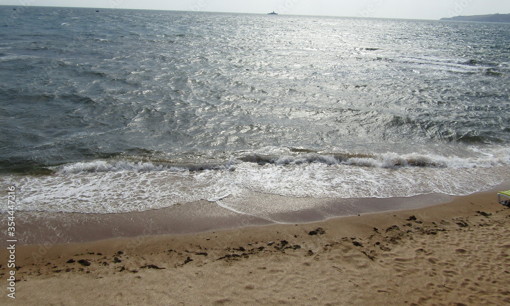 Море штормит на берегу песчаного пляжа Феодосии у эллинов на черноморской набережной 