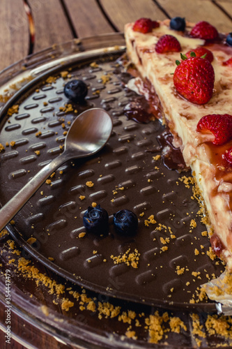 Half delicious cheese cake with small red strawberries