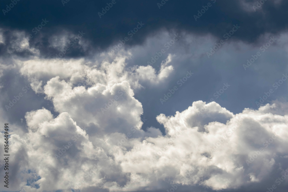 Detail of towering dramatic clouds in the Andean skies, stormy cloud formations laden with water about to precipitate, contrasted by the afternoon lights. Detail of towering dramatic clouds in the Andean skies, stormy cloud formations laden with water about to precipitate, contrasted by the afternoon lights.