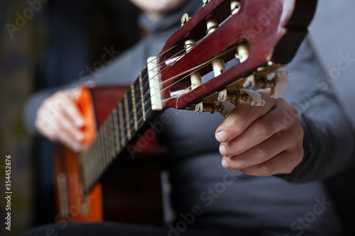 Fotografía girl tunes an acoustic guitar close-up