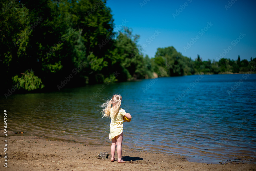 Mädchen schaut auf den See, Wind entwickelt Haare