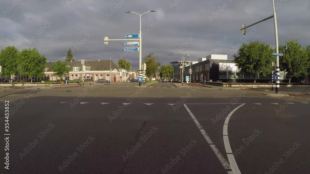 POV shot of road intersection with vehicles in city against cloudy sky on sunny day - Breda, Netherlands POV shot of road intersection with vehicles in city against cloudy sky on sunny day - Breda, Netherlands
