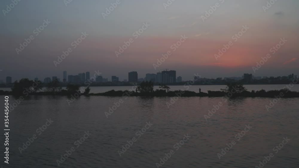 Hanoi - Time lapse - Sunset in West Lake with fisherman in silhouette Hanoi - Time lapse - Sunset in West Lake with fisherman in silhouette