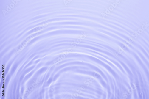 Soft focus lite purple blue gray cosmetic moisturizer floral water  micellar toner  or emulsion abstract background. Reflections of  scattered sun texture.