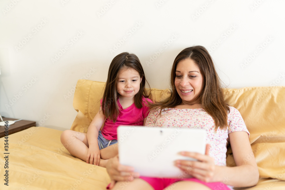 Kid and parent using a tablet in bed Kid and parent using a tablet in bed