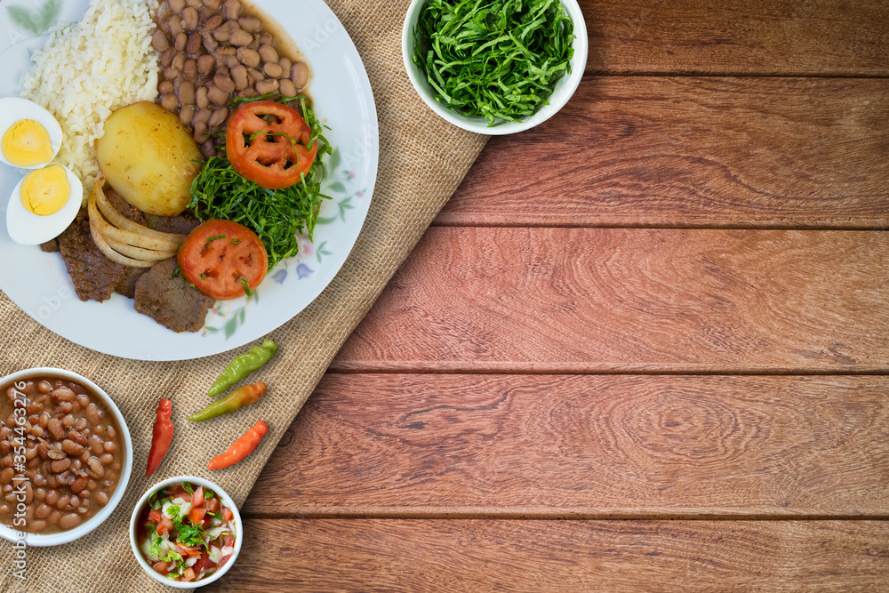 Brazilian food dish. Wood background. Top view. Brazilian food dish. Wood background. Top view.