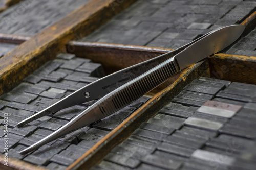 clamps on old vintage wood drawers for letterpress, with their types of lead in it. Selective focus. Printing press concept photo