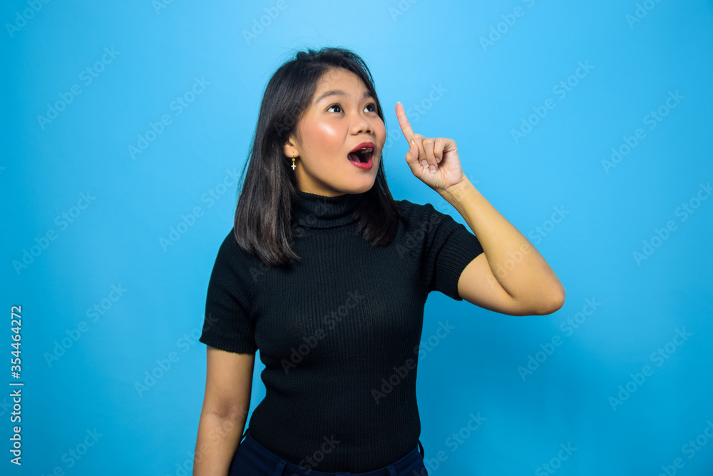 Portrait of Young beautiful asian women wearing black turtle neck shirt with blue isolated background Portrait of Young beautiful asian women wearing black turtle neck shirt with blue isolated background
