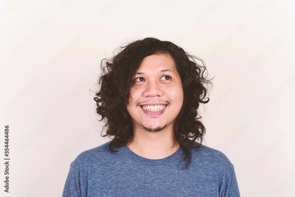 Portrait of Asian man face smiling on white concrete wall Portrait of Asian man face smiling on white concrete wall