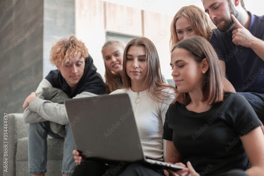 Group of young colleagues using laptop at office Group of young colleagues using laptop at office