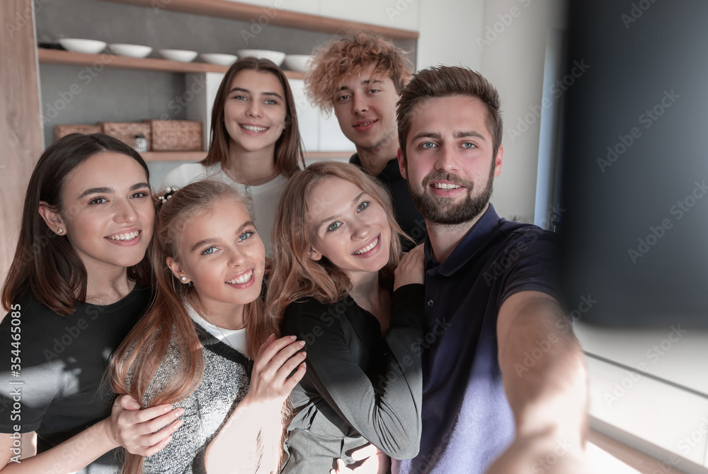Image of happy young friends at home take a selfie by camera Image of happy young friends at home take a selfie by camera