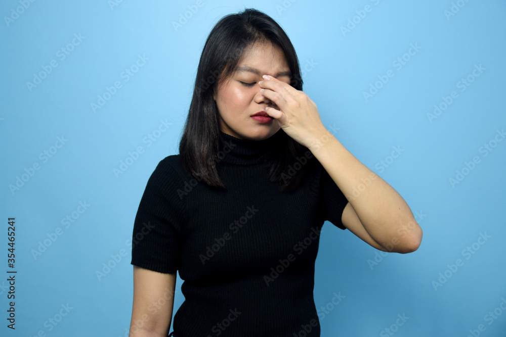 Portrait of Young beautiful asian women wearing black turtle neck shirt with blue isolated background, Headache Expression Gesture Portrait of Young beautiful asian women wearing black turtle neck shirt with blue isolated background, Headache Expression Gesture