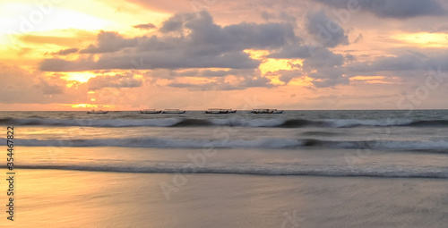 Fototapeta Naklejka Na Ścianę i Meble -  Beautiful Sunset at  Bali Beach featuring fisherman boat