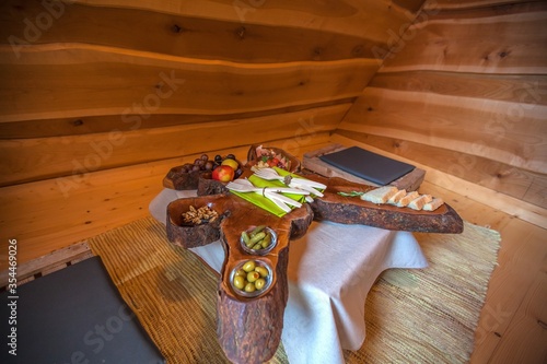 Closeup of a rustic dining set with fruits, bread and nuts served on a sliced wood photo