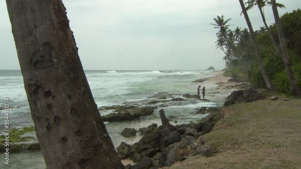 Lockdown shot of shirtless teenage boys standing on shore at beach against sky - Arugam Bay, Sri Lanka Lockdown shot of shirtless teenage boys standing on shore at beach against sky - Arugam Bay, Sri Lanka