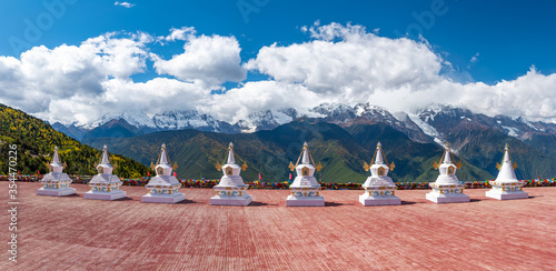 traditional Tibetan buddhist style white pagoda with Meili snow mountain in background in Deqen, Shangri-la country,  Yunnan province, China photo