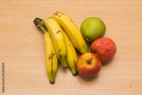 Colorful fresh summer fruits on yellow wooden background, healthy organic food on table, detox vitamin nutrition for health care, top close up view, copy space