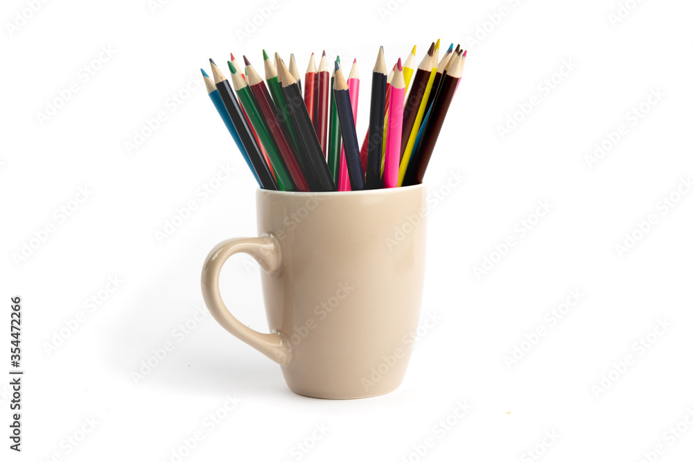a coffee cup full of sharp colorful pencil crayons isolated on white a coffee cup full of sharp colorful pencil crayons isolated on white