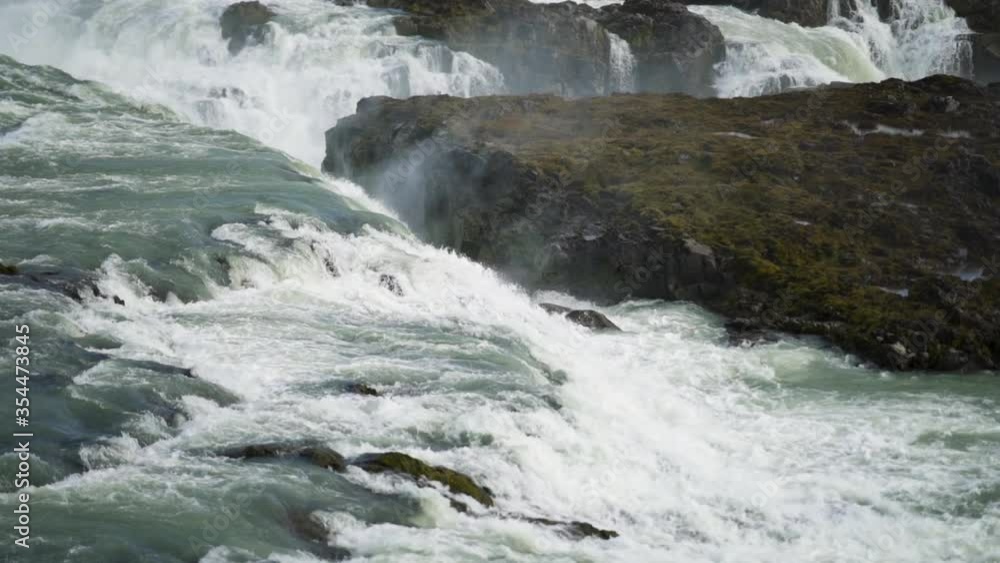 Breath-taking medium close-up shot of waterfall in Iceland. Fast water is gushing down over the rocks and the waterspray makes for an evocative feel. Breath-taking medium close-up shot of waterfall in Iceland. Fast water is gushing down over the rocks and the waterspray makes for an evocative feel.