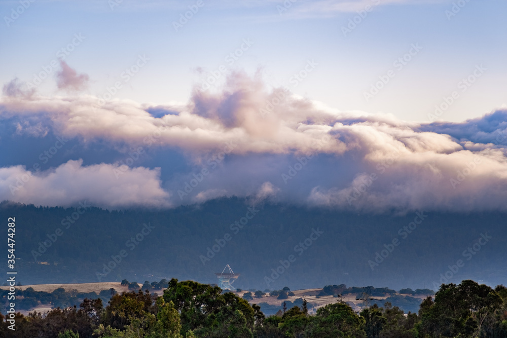 Sunset view of a blanket of clouds covering the forests of Santa Cruz Mountains, Stanford Dish visible in the foreground; San Francisco Bay Area, California Sunset view of a blanket of clouds covering the forests of Santa Cruz Mountains, Stanford Dish visible in the foreground; San Francisco Bay Area, California
