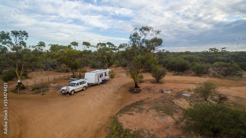 Low level drone view of a 4WD and a caravan in the Australian outback. © Philip Schubert