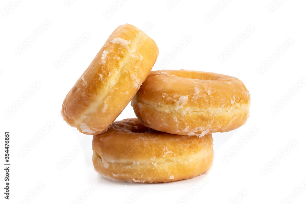 a pile of three sweet honey glazed donuts isolated on white