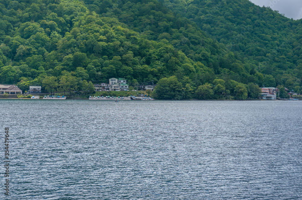 Lake Chuzenji and mountains landscape with waterfront buildings Lake Chuzenji and mountains landscape with waterfront buildings