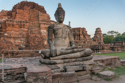 Ruins of old Thai temple with sitting Buddha statue